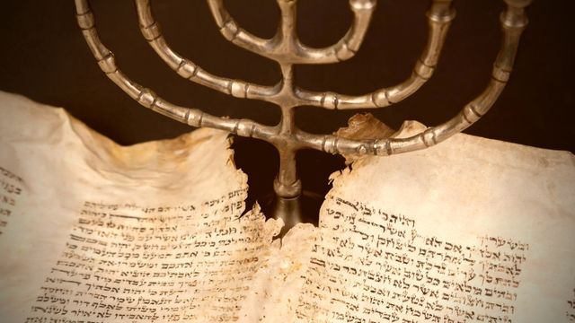 um candelabro diante de um manuscrito antigo